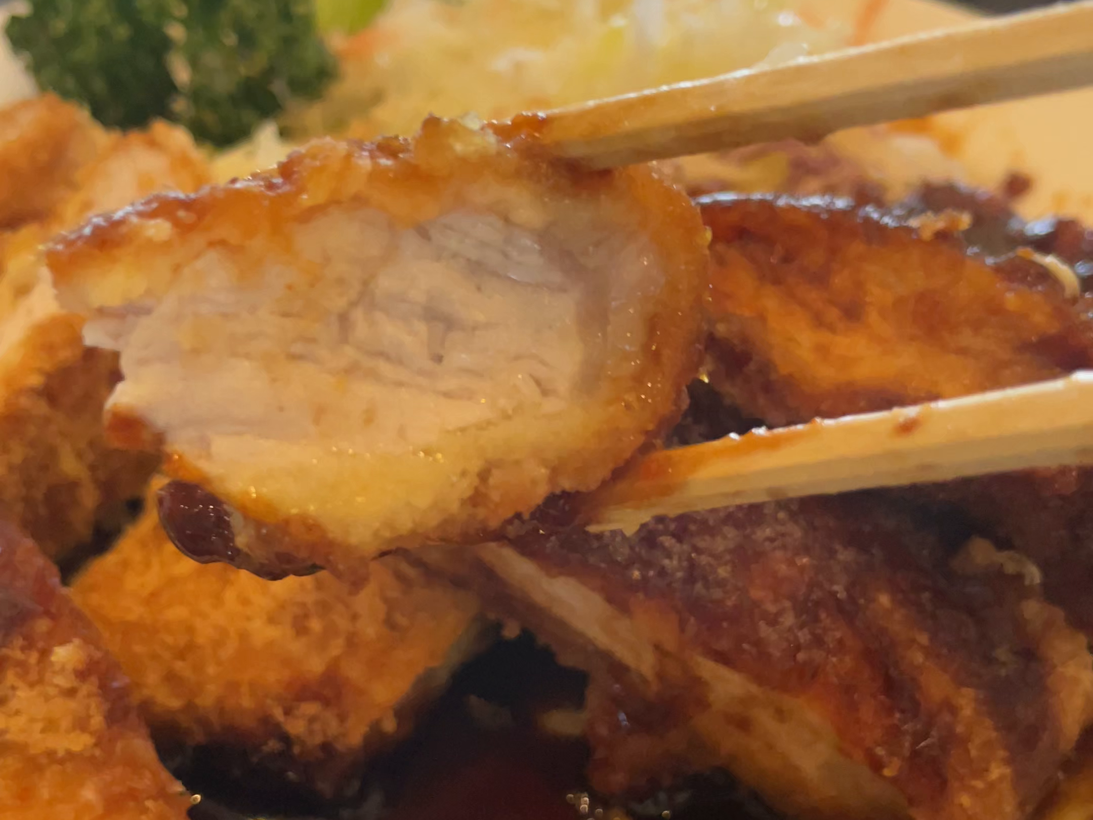 とんかつの断面を箸で見せる