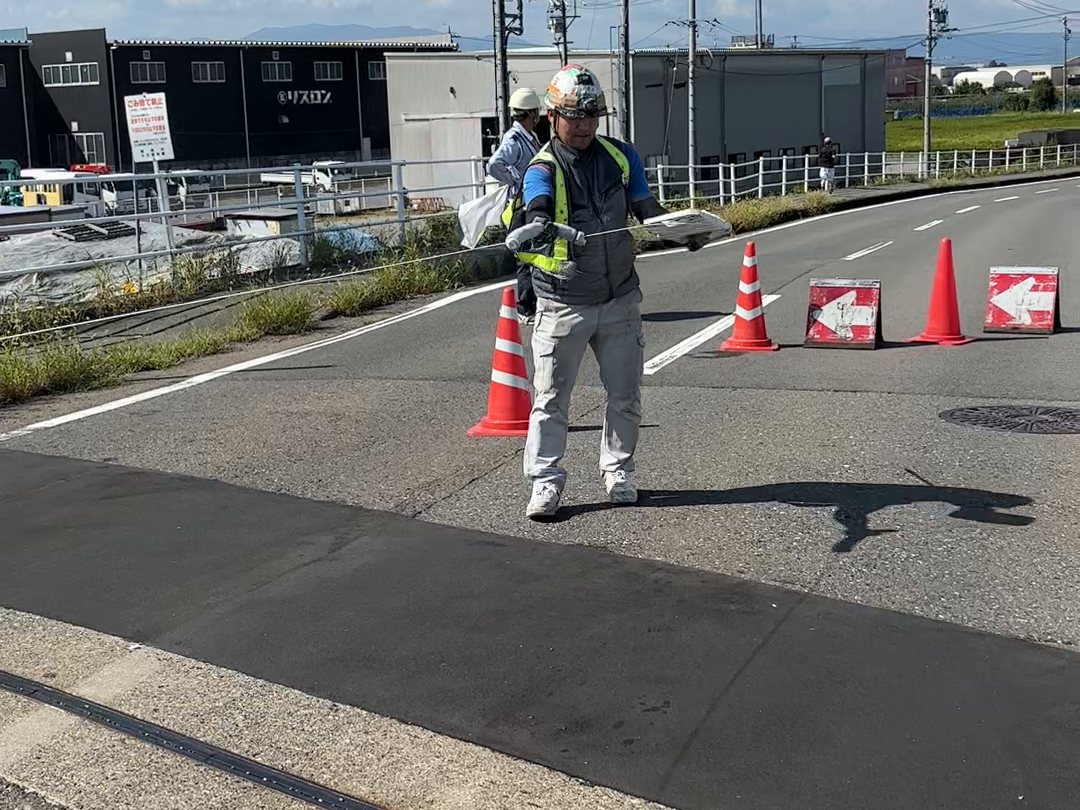 道路のコーン付近に立つ作業員