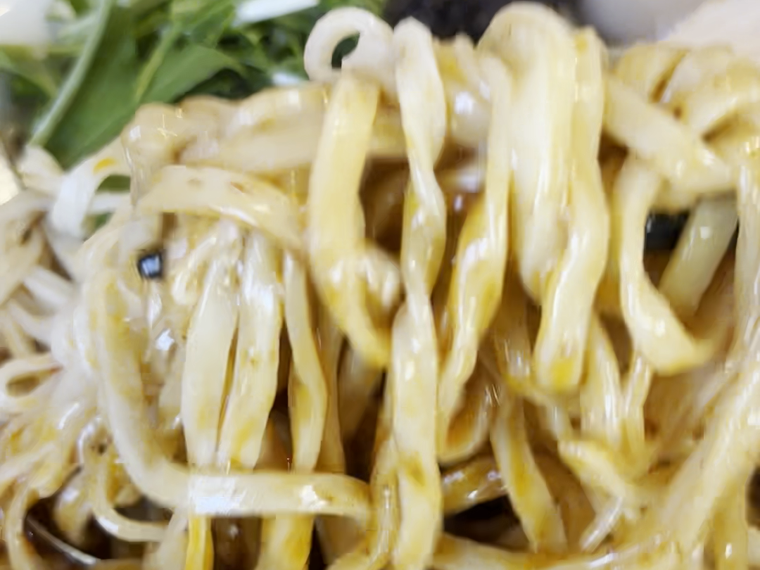 たれを絡めた麺を箸で持ち上げる