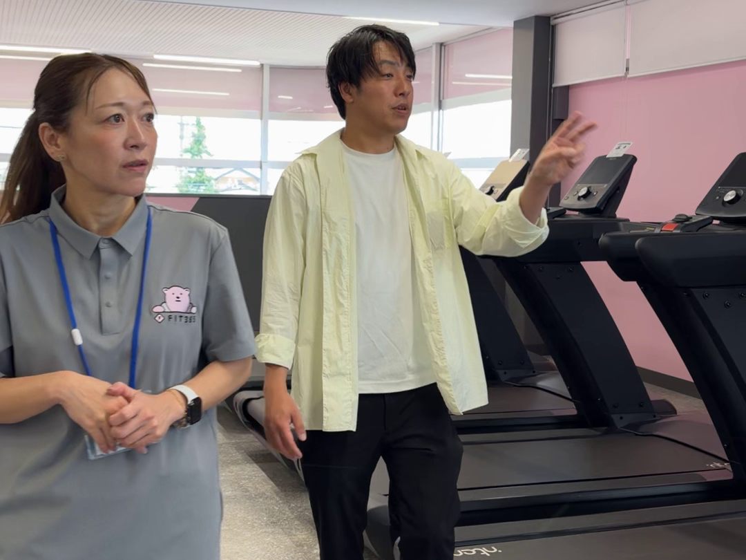 スタッフと施設を見学する取材時の場面