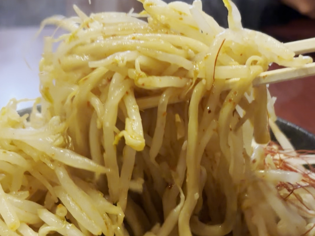 箸で麺を持ち上げる場面